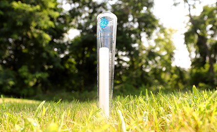 A clear rain gauge with the QC logo.